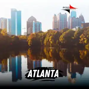 Thirteen skyscrapers stretch out from a nestle of bushes. The striking scene is mirrored across the water which shows a reflection of the nature and city. The Bond Investigations logo is top right and bottom cented text reads Atlanta.